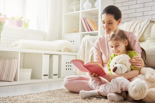 mother reading to daughter stock photo