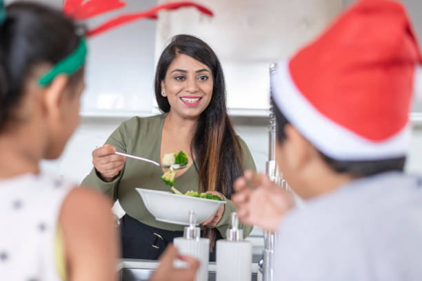 Mother serving children food on Christmas stock photo