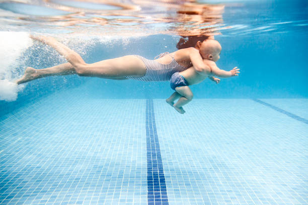 mother swimming with baby boy - swimming baby stockfoto's en -beelden