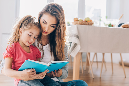 Mother Teaching Her Daughter How To Read Stock Photo