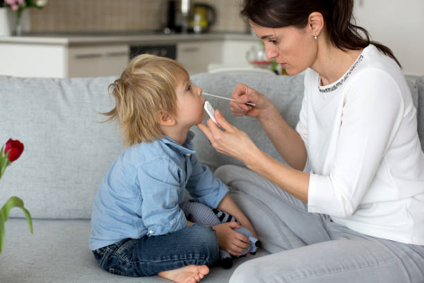 Mother, testing her child for covid at home, making home allowed swab tests stock photo