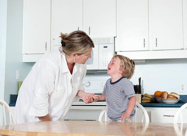Mother trying to calm crying child at home stock photo
