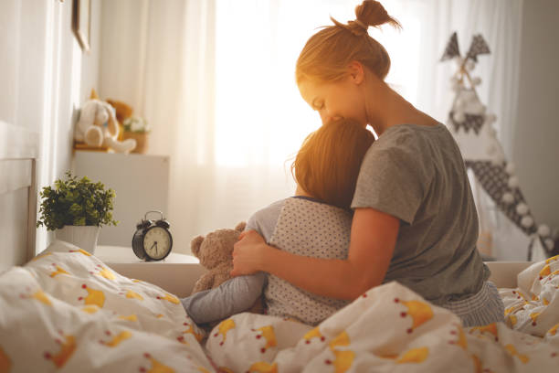 mother wakes her daughter in bed in  morning - família monoparental imagens e fotografias de stock