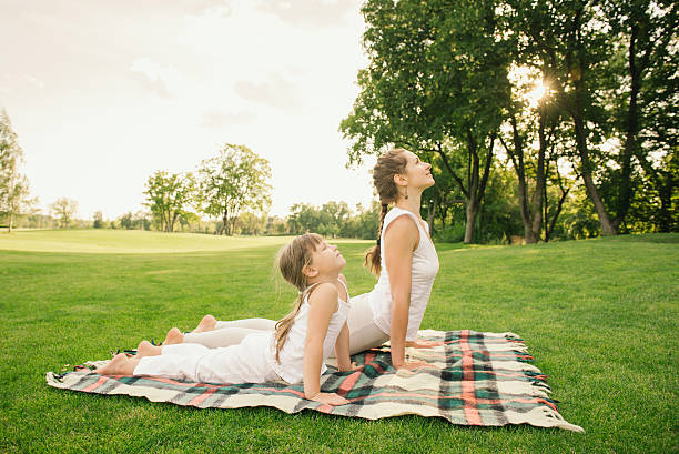 Mother with child doing yoga exercise stock photo