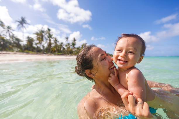 A mother with her son are swimming and playing in a sea stock photo