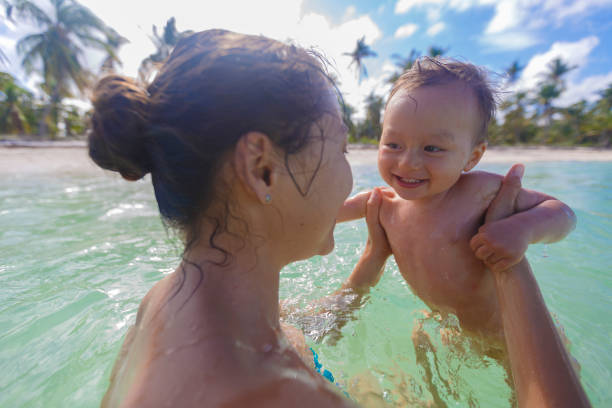 A mother with her son are swimming and playing in a sea stock photo