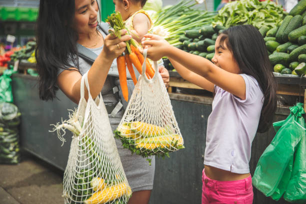 Mother with kids shopping in market Asian mother with kids shopping in market fresh foods indonesian girl stock pictures, royalty-free photos & images