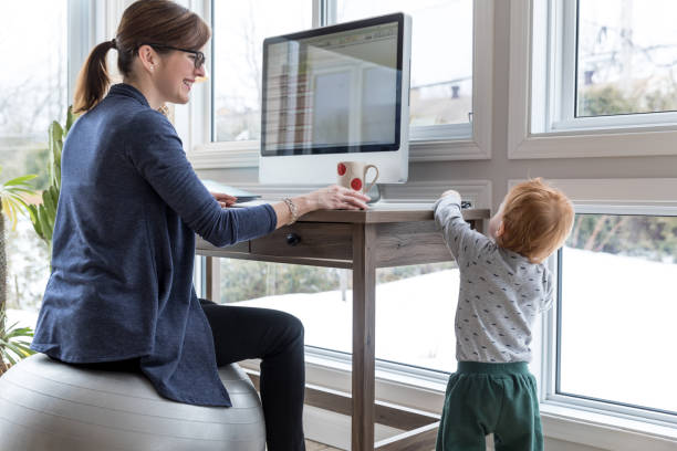 Mother Working From Home with Kid Mother Working From Home with baby boy playing around yoga ball work stock pictures, royalty-free photos & images
