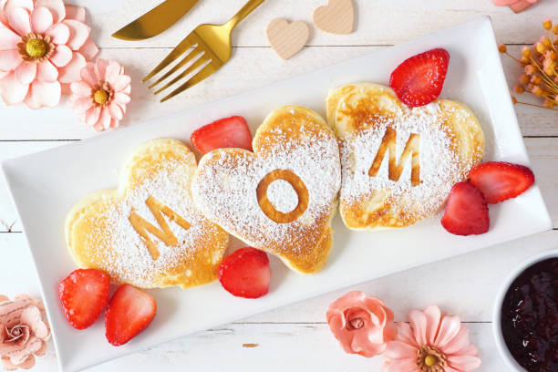 muttertag frühstück herzförmige pfannkuchen mit mom buchstaben, top-ansicht tisch-szene auf weißem holz - brunch stock-fotos und bilder