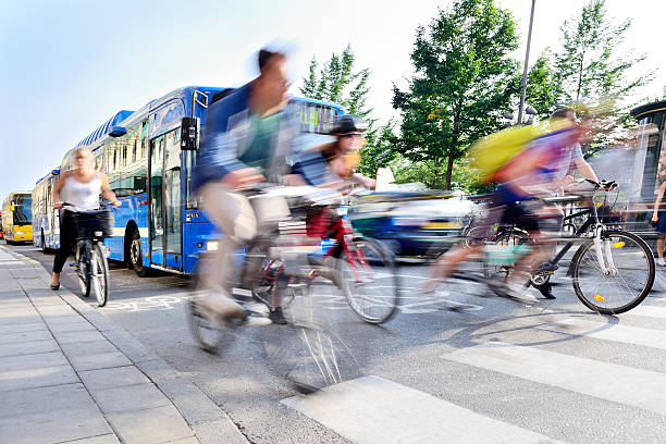 Motion blurred bicyclists in traffic stock photo