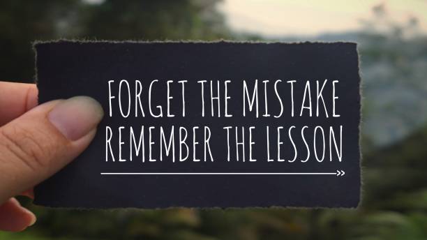 Motivational and inspirational quote. ‘Forget the mistake, remember the lesson’ written on a black paper. Vintage styled background. mistake stock pictures, royalty-free photos & images