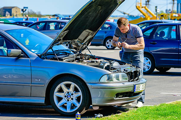 Motor problems Karlskrona, Sweden - May 3, 2016: Male person working under the hood of a 2005 BMW 525 touring on a parking lot in the harbor. Hood is open and person is using tools on the motor. bmw stock pictures, royalty-free photos & images