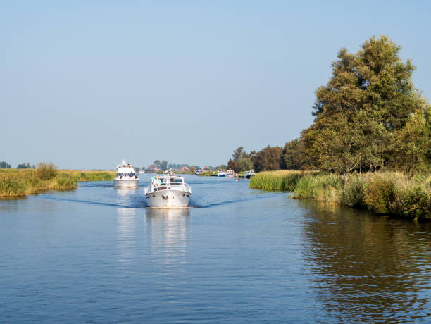 Motorboats cruising on canal in national park Alde Feanen, Friesland, Netherlands stock photo