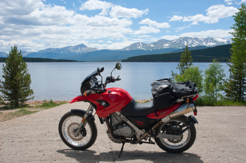 Leadville, United States - July 24, 2011: This red BMW F650 GS motorcycle is parked at the boat ramp overlooking Turquoise Lake, near Leadville, Colorado.  A motorcycle ride around a Rocky Mountain lake is a great way to cool off in the summer heat!