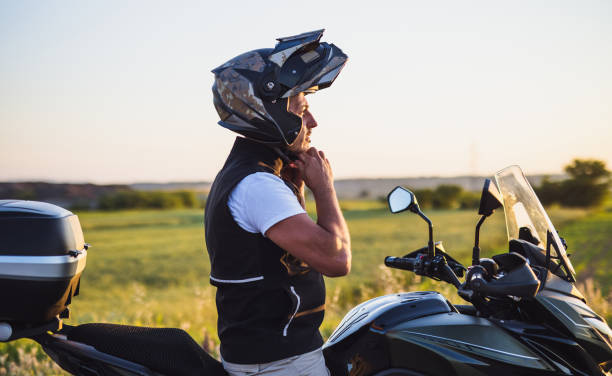 Motorcyclist adjusting crash helmet stock photo