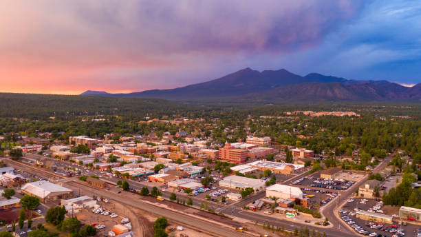Mount Humphreys at sunset overlooks the area around Flagstaff Arizona Blue and Orange color swirls around in the clouds at sunset over Flagstaff Arizona coconino county stock pictures, royalty-free photos & images