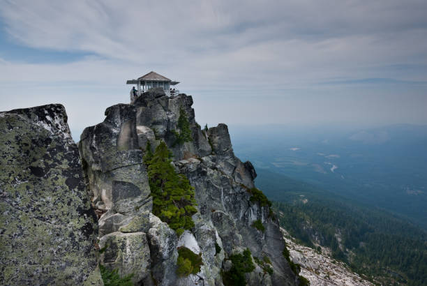 Mount Pilchuck Fire Lookout The historic Mount Pilchuck fire lookout was originally built in 1918 and rebuilt for visitor use in 1990. The lookout can be reached by hiking through beautiful old-growth forest and heather-covered meadows to the rocky summit. There you can see an incredible panoramic view of the Puget Sound lowlands and the Cascade and Olympic Mountains. Mount Pilchuck is near Granite Falls, Washington State, USA. jeff goulden fire lookout stock pictures, royalty-free photos & images