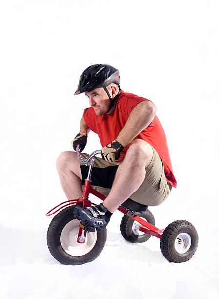 Mountain Biker A large man riding a child's bike pretending to be a mountain biker. adult tricycle stock pictures, royalty-free photos & images