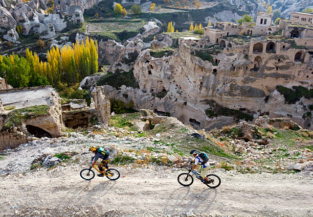Mountain bikers exploring new routes in Turkey Mountain bikers rushing through a dirt road in the beautiful area of Cappadocia, Turkey  eco tourism stock pictures, royalty-free photos & images