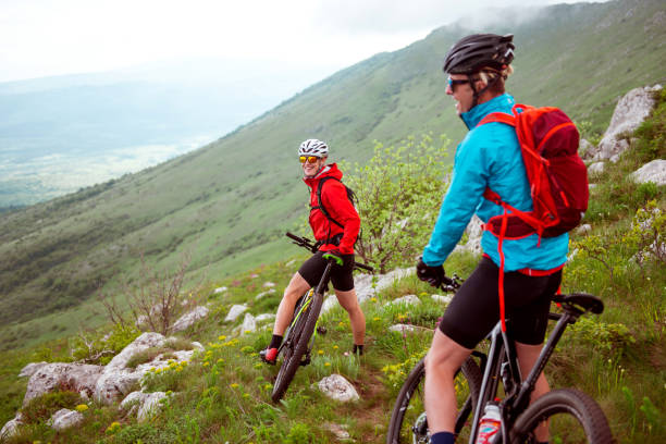 Mountain biking Male and female bikers are having a ride in the mountains. georgijevic mountain biker stock pictures, royalty-free photos & images