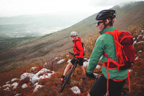 Mountain cycling Male and female bikers are having a ride in the mountains. georgijevic mountain biker stock pictures, royalty-free photos & images