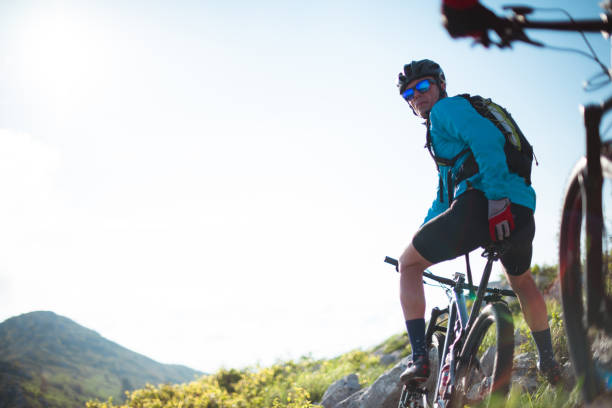 Mountain cycling Male and female bikers are having a ride in the mountains. georgijevic mountain biker stock pictures, royalty-free photos & images