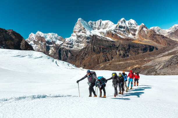 Mountain Panorama View and Climbers walking up on Snow Terrain stock photo