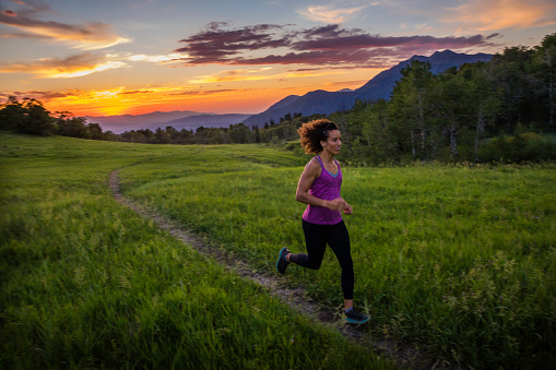 A woman enjoys a summer afternoon and evening running on a trail in the mountains above Provo, Utah.