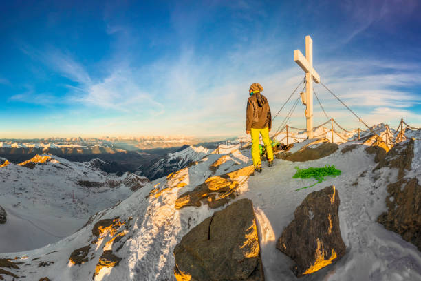 Mountaineer at Summit Cross of Kitzsteinhorn Ski resort Kaprun in Austrian Alps, Tyrol State - Austria hohe tauern range stock pictures, royalty-free photos & images