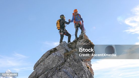istock Mountaineers high five on mountain summit 1331838690