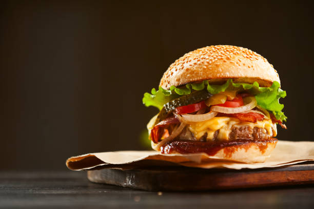 mouth-watering delicious homemade burger used to chop beef on the wooden table. stock photo