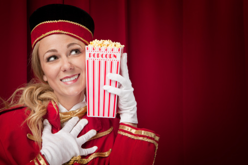 ✓ Movie theater usher enjoys her popcorn Stock Photos
