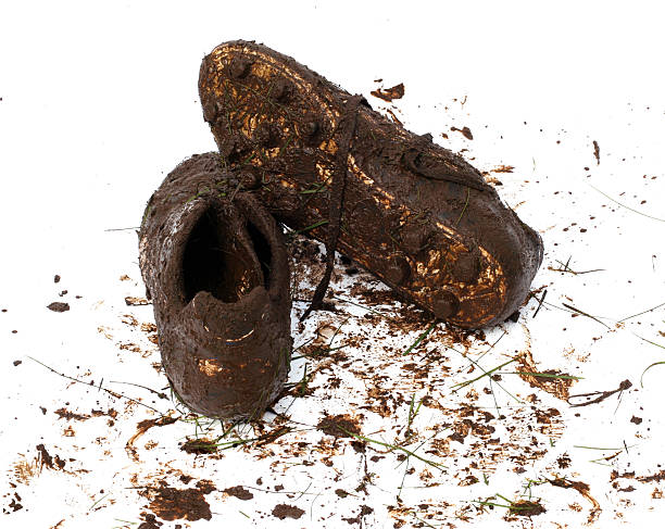 muddy football shoes after the game - muddy shoes stockfoto's en -beelden