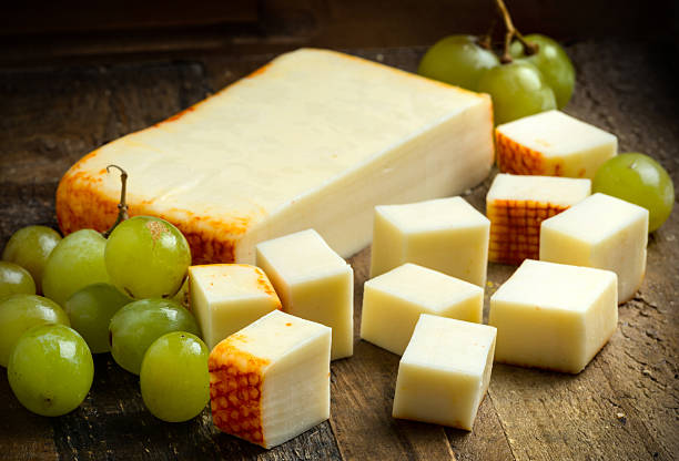 Muenster Cheese Muenster Cheese and grapes over a wooden table muenster cheese stock pictures, royalty-free photos & images