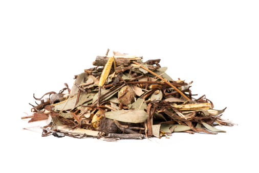 A pile of mulch made up of leaves and twigs on a white background.