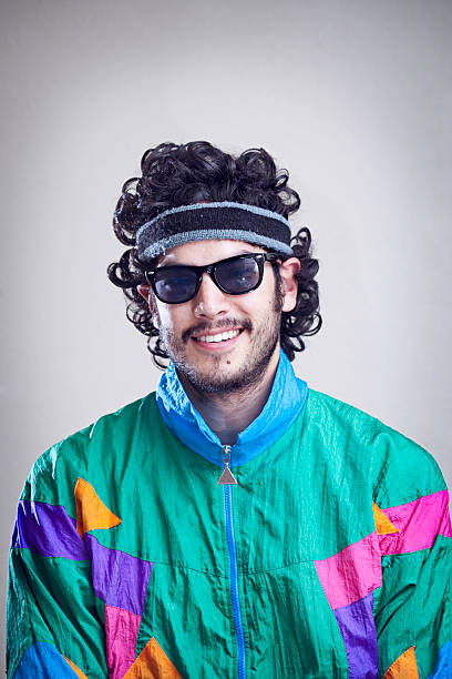 Mullet Man With 1980's-1990's Fashion Style A cool, funky young adult from the late 20th century complete with mullet, fluorescent track suit, and tinted sun glasses.  Vertical with copy space. mullet haircut photos stock pictures, royalty-free photos & images