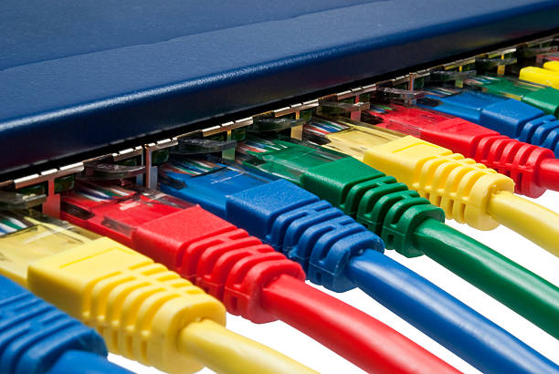 Multi color ethernet network plugs connected to a router / switch stock photo
