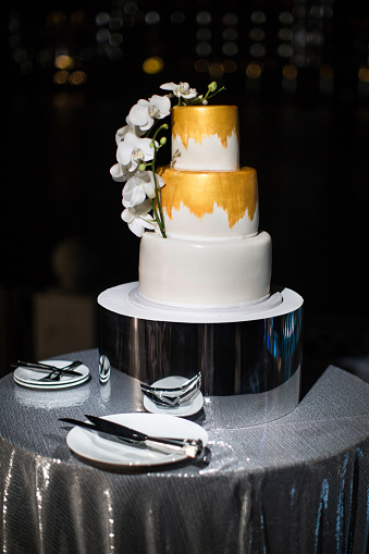 Multi level wedding cake with flowers on the silver table.