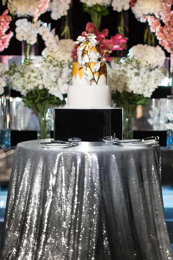 Multi level wedding cake with flowers on the silver table.