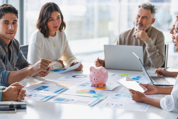 Multi racial group of Business people with a piggy bank. There are people of different ethnic groups stock photo