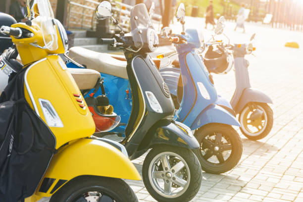 ciclomotori multicolori nel parcheggio della città - electric scooter foto e immagini stock
