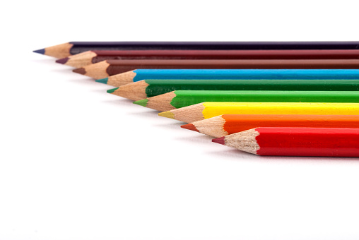 Colored wooden pencils in complementary color isolated on white desktop. Close up.