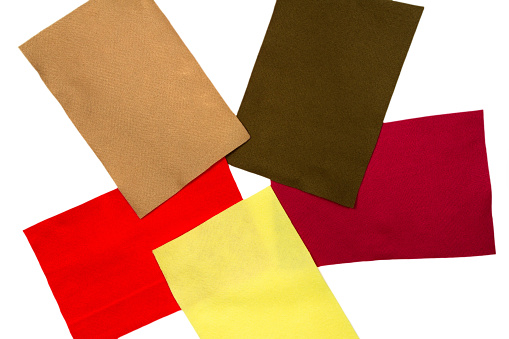 Multicolored rectangles of fabric on a white background. The texture of the wool fabric.