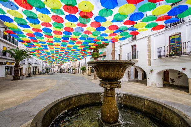 Multi-colored umbrellas background. Colorful umbrellas floating above the stree stock photo