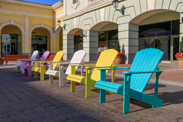 multicolored wooden benches stand on the street with shops in the background. Sunny day, summer. stock photo