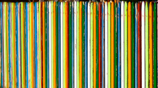 Multicolored wooden fence surrounding a children playground , close-up  view suitable for backgrounds, diminishing perspective. Galicia, Spain.