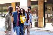 istock Multicultural friends walking in city center - Happy guys and girls having fun around shopping town streets - University students on travel vacations 1352082270