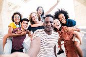 istock Multicultural happy friends having fun taking group selfie portrait on city street - Young diverse people celebrating laughing together outdoors - Happy lifestyle concept 1326296808