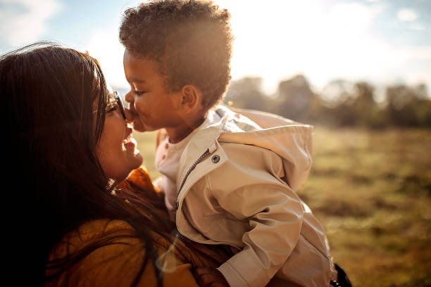 Multi-ethic mother and son spending time together outdoors stock photo