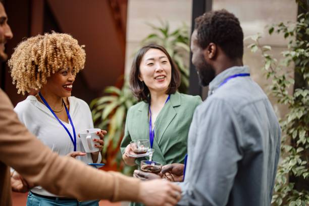 Multiethnic business people talk during a coffee break stock photo